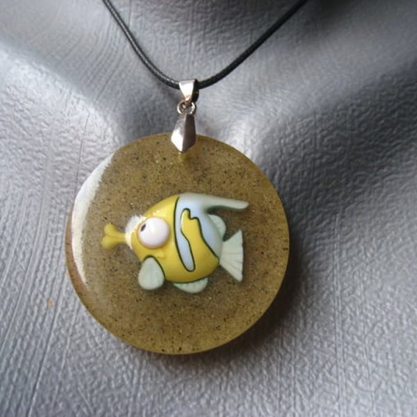 PROMOTION Pendentif estival unisexe poisson tropical sur fond de sable en résine diamètre 40mm création unique