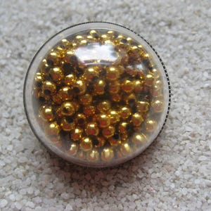 Unisex ring necklace jewelry with mobile golden beads set in resin in a plexiglass sphere, diameter 30mm