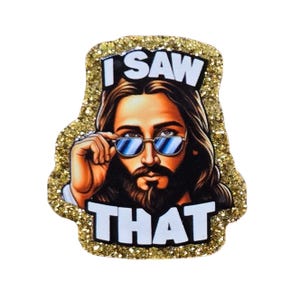 May include: A decorative pin featuring a graphic illustration of a bearded figure with long brown hair wearing blue-tinted sunglasses. The text I SAW THAT is printed in white block letters above and below the figure, set against a gold glitter background.