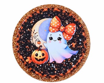 May include: A round Halloween-themed design featuring a cute ghost with a polka-dot bow, a jack-o'-lantern, and a crescent moon. The background is black with orange accents and gold glitter edging. The design is perfect for Halloween.