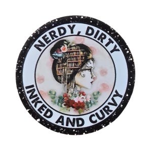 May include: A circular button with a black glitter border featuring an illustration of a person with a bookshelf for hair, glasses, and floral accents. The text NERDY, DIRTY, INKED AND CURVY is printed in black capital letters around the white center.