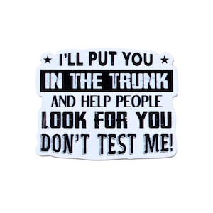 May include: A white sticker with black text that reads "I'LL PUT YOU IN THE TRUNK AND HELP PEOPLE LOOK FOR YOU DON'T TEST ME!" The text is in a bold, sans-serif font.