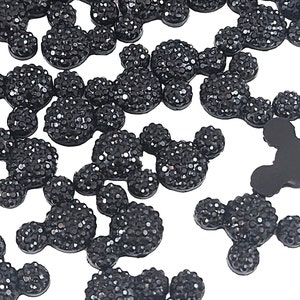 May include: A large quantity of black, sparkly, Mickey Mouse-shaped resin embellishments.