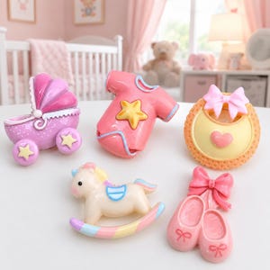 May include: A set of five decorative resin ornaments featuring a purple baby carriage with yellow stars, a pink baby onesie with a yellow star, a yellow bib with a pink bow and heart, a cream rocking horse, and pink ballet slippers with a bow.