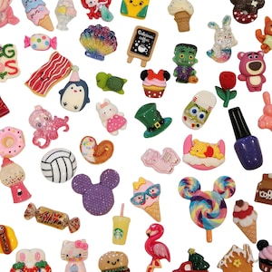 May include: A collection of assorted colorful resin flatback charms featuring various shapes including food items like ice cream cones, donuts, and candy, animals such as a flamingo, turtle, and octopus, and cartoon characters, all with a glossy finish.
