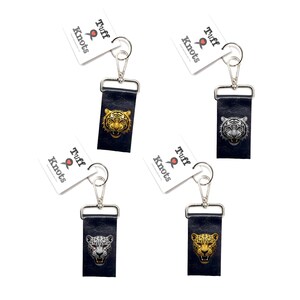 May include: Four rectangular black leather keychains with silver metal lobster clasps and white tags labeled Tuff Knots. Each keychain features a different big cat head graphic: a gold tiger, a white tiger, a spotted leopard, and a jaguar.