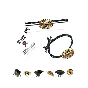 May include: A collection of hair accessories featuring a zebra print design. The image includes a black elastic hair tie, a black cord bracelet, and several hair pins. The accessories have a central oval-shaped element with a zebra pattern.