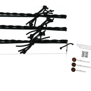 Peut inclure: Trois &eacute;lastiques &agrave; cheveux tress&eacute;s noirs avec de petits charmes en forme de c&oelig;ur noirs. Les &eacute;lastiques &agrave; cheveux sont emball&eacute;s sur une carte blanche avec un code QR et le texte "Strong & Stretchy Hair Ties so stylish they can also be worn as a Bracelet!"  TuffKnots.com TuffKnots@icloud.com @tuffknots
