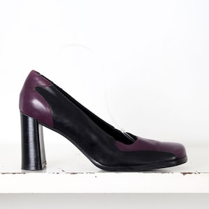 May include: Black and purple leather heeled pumps with a chunky heel.