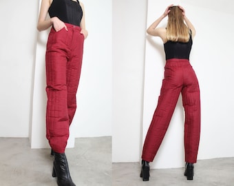 May include: Red quilted pants with a straight leg fit. The pants have a zipper and button closure at the waist.