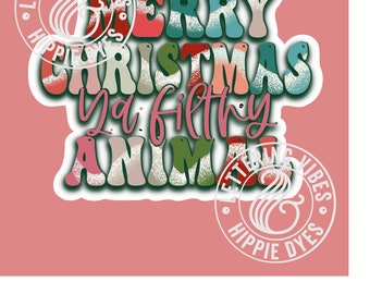 May include: A colorful sticker with the text "Merry Christmas Ya Filthy Animal" in a retro font. The sticker has a white border and a distressed, vintage look. The text is in shades of red, green, blue, and white.