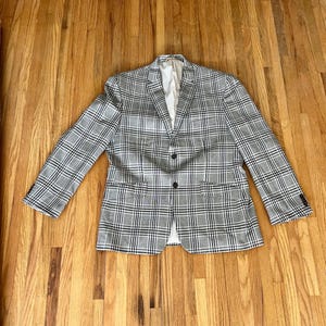 May include: A gray and white plaid blazer with two black buttons.