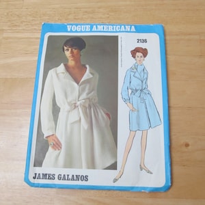May include: A vintage Vogue Americana sewing pattern featuring a white dress and a light blue coat design. The pattern cover includes the text "VOGUE AMERICANA", the number "2136", and the designer's name "JAMES GALANOS".