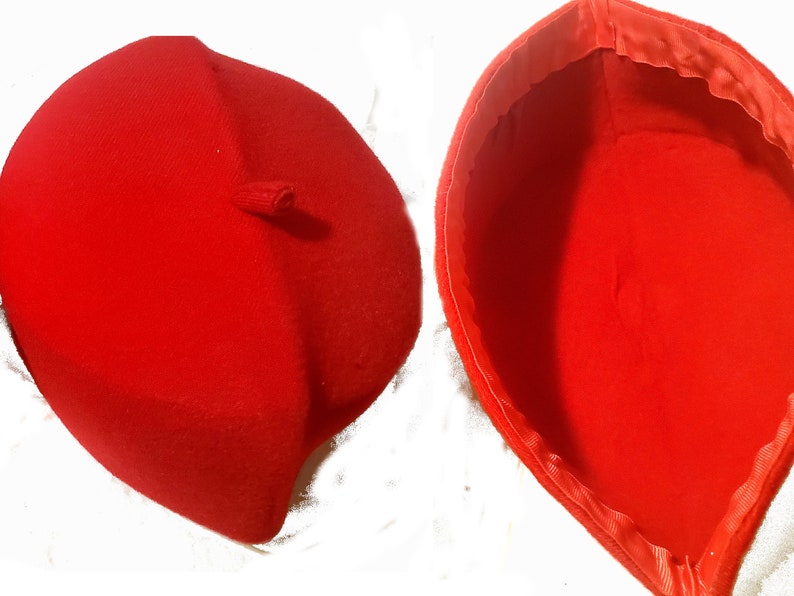 May include: A red beret with a small loop on the top. The beret is shown from both the outside and inside.