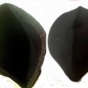 May include: A black fabric hat with a soft, flexible texture. The hat is shown inside out and right side out.