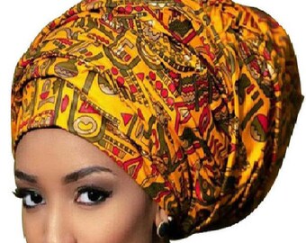 Puede incluir: Un turbante amarillo con un patrón geométrico en rojo, verde y dorado.