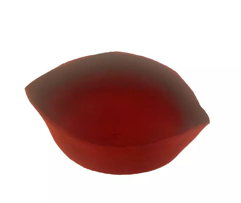 May include: A red, heart-shaped dish with a smooth, glossy finish. The dish is made of a translucent material and has a slight curve to the bottom.