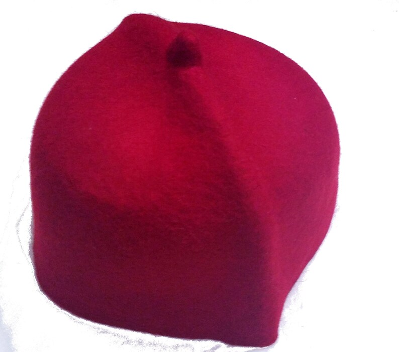 May include: A red felt fez hat with a small round top.