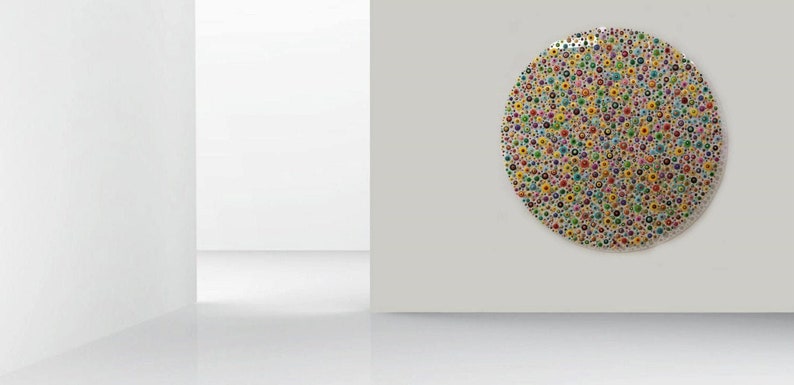 May include: A large, circular wall art piece with a white background and a pattern of colorful dots. The dots are arranged in a random pattern and are of various sizes and colors, including red, yellow, blue, green, and purple.