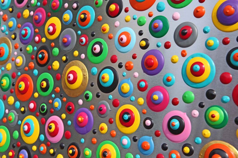 May include: A silver background with a pattern of colorful circles with concentric rings. The circles are in various sizes and colors, including red, yellow, blue, green, and purple.