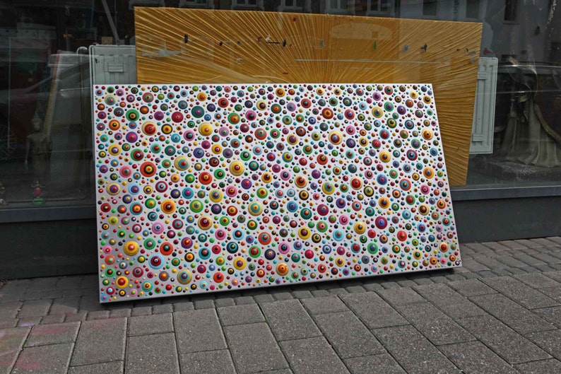 May include: A white rectangular canvas covered in hundreds of colorful circles, creating a vibrant and abstract pattern.