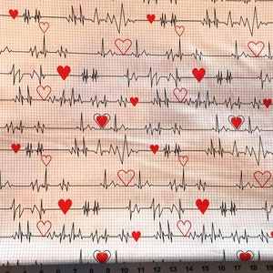 May include: White fabric with a repeating pattern of black EKG heartbeats and red hearts. The fabric has a grid pattern.