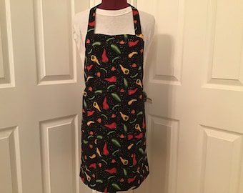 May include: A black apron with a red, yellow, and green chili pepper pattern. The apron has two pockets and adjustable straps.