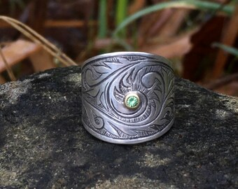 Green garnet saddle ring, wide engraved sterling silver band, 18 karat gold bezel, carved scrollwork design, fits size 7.75, measures 8.5