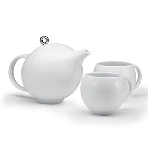 以下が含まれることがあります： 銀色の蓋が付いた白いセラミック製のティーポットと、それに合わせた白いセラミック製のティーカップ2つ