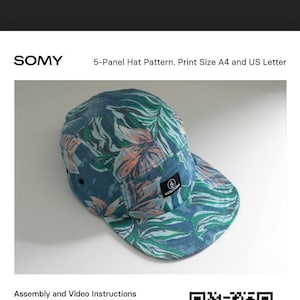 Pu&ograve; includere: Un cappello a cinque pannelli con un motivo a foglie tropicali nei toni del blu, verde e corallo. Il cappello presenta una piccola etichetta nera con testo bianco e un logo circolare. Il testo "SOMY" &egrave; nella parte superiore dell'immagine, insieme a "5-Panel Hat Pattern."