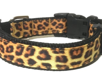 May include: A black and brown leopard print dog collar with a black plastic buckle.