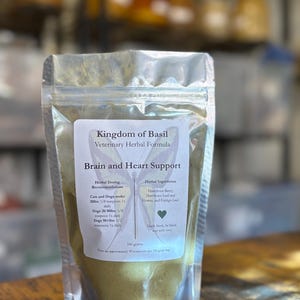 May include: A white resealable pouch with a green label that reads "Kingdom of Basil Veterinary Herbal Formula Brain and Heart Support". The label also includes a list of herbal ingredients and dosing recommendations for cats and dogs.