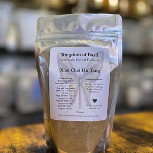 May include: A silver pouch of "Kingdom of Basil" veterinary herbal formula, "Xiao Chai Hu Tang." The label includes dosing recommendations for cats and dogs, and lists herbal ingredients. The bag contains 100 grams of product.