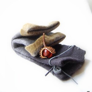 May include: A set of three gray and brown felt pouches with a single brown chestnut inside the largest pouch.