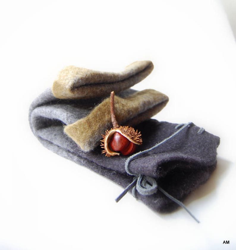 May include: A set of three gray and brown felt pouches with a single brown chestnut inside the largest pouch.
