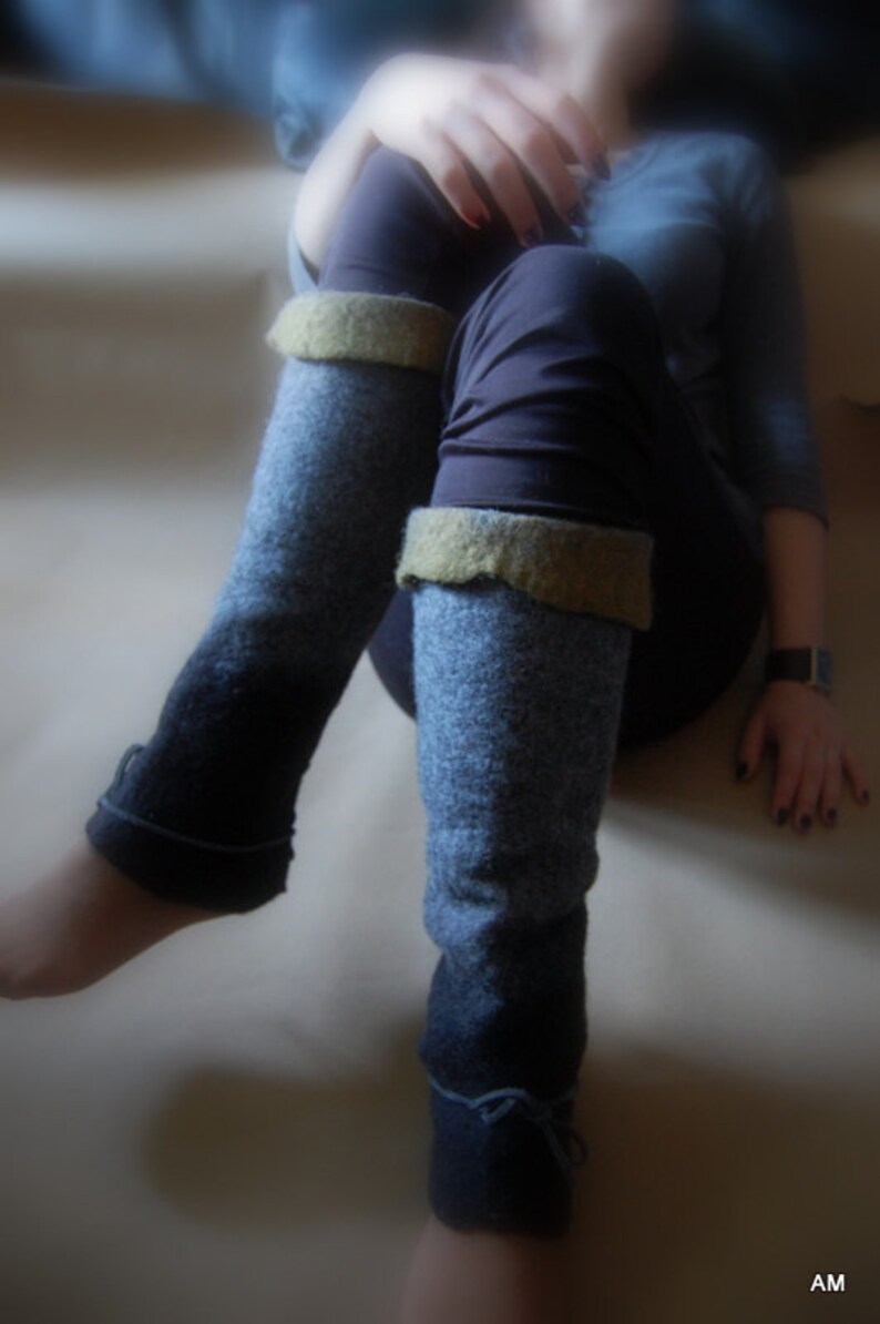 May include: A pair of blue and gray leg warmers with a brown cuff. The leg warmers are made of a soft, knitted fabric.
