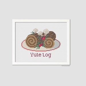 May include: A cross-stitch pattern of a Yule Log, a traditional Christmas dessert, on a white plate with red trim. The log is decorated with green leaves and red berries. The text "Yule Log" is written below the image.