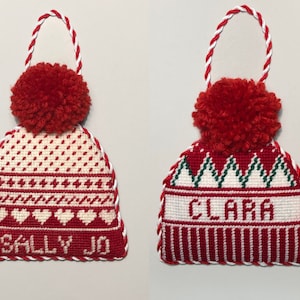 May include: Two red and white knit stocking cap ornaments with pom-poms. One ornament says "Sally Jo" and the other says "Clara".