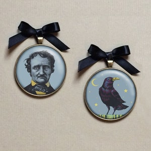May include: Two round, bronze-colored ornaments with black ribbon hangers. The first ornament features a black and white portrait of Edgar Allan Poe. The second ornament features a black raven with a yellow beak and yellow stars on a blue background.