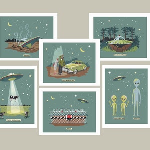 May include: A set of 7 illustrated cards depicting various UFO sightings. The cards feature a crashed UFO, a UFO over a forest, a UFO abducting cows, a UFO over a car, a UFO over a fence, and two aliens standing next to a tall alien.