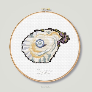 May include: A cross-stitch pattern of an oyster with a pearl inside, framed in a wooden hoop. The text "Oyster" is below the image, and the text "© 2022 Lisa Zador" is below that.