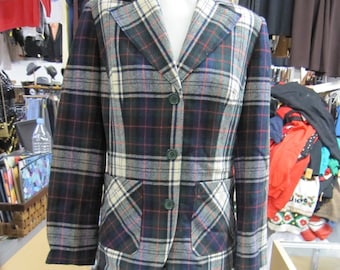 Op de afbeelding: Een getailleerd pak met blazer en rok in een groene, witte en rode ruit. De blazer heeft een reverskraag, lange mouwen en een knoopsluiting. De rok is knielengte en heeft een rechte pasvorm.