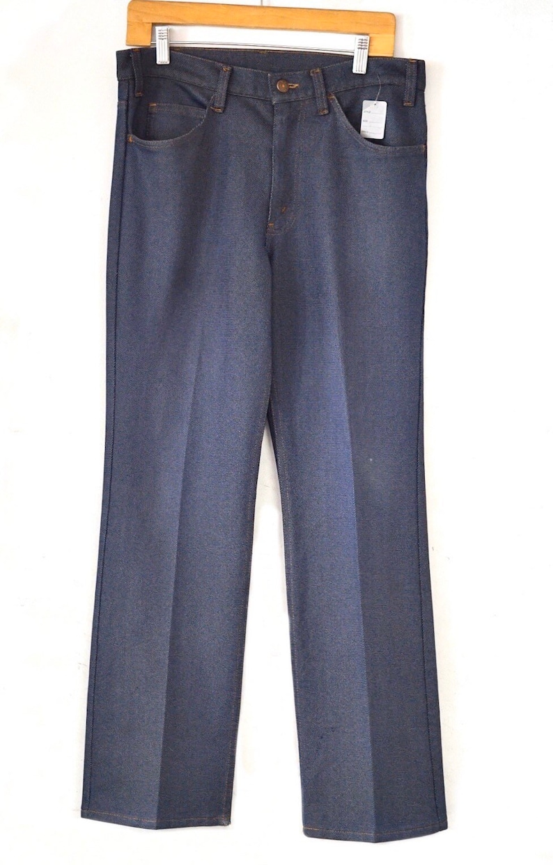 May include: A pair of dark blue denim jeans with a straight leg fit. The jeans have a classic five-pocket design and a button fly.