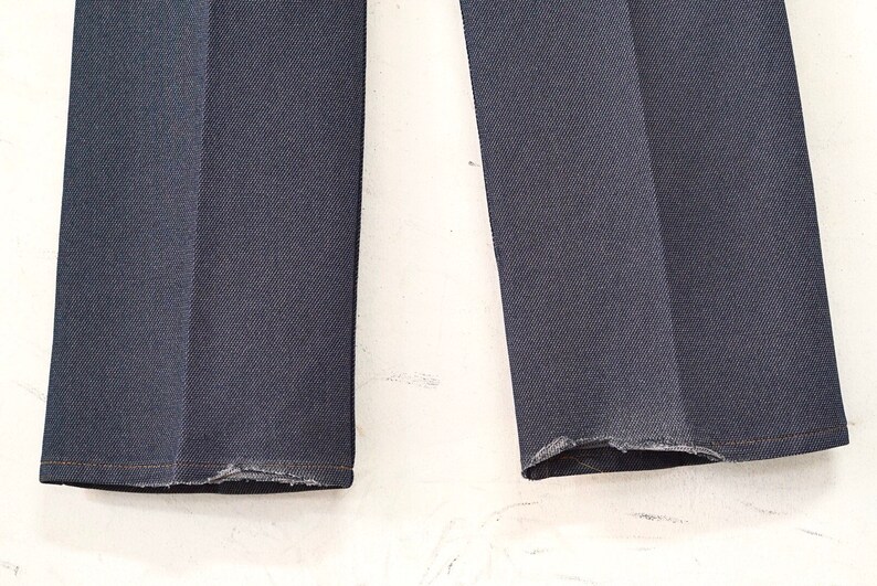May include: A pair of dark blue denim jeans with frayed hems.