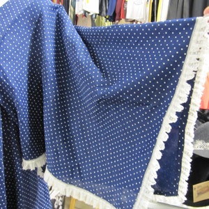 May include: A blue dress with white polka dots and a white lace trim. The dress has a loose, flowing silhouette.