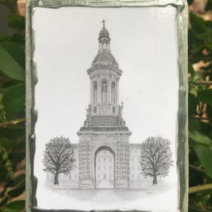May include: A black and white drawing of a building with a tall tower and a large archway. The drawing is on a white background and is framed in a silver frame.
