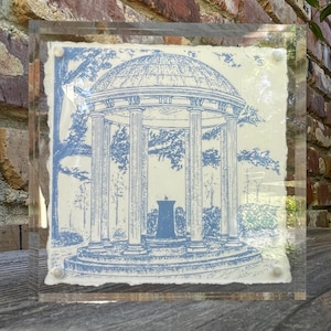 May include: A framed print of a blue and white illustration of the Old Well, a historic landmark at the University of North Carolina at Chapel Hill.