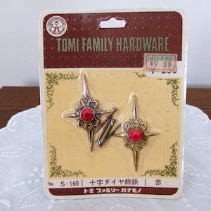Puede incluir: Paquete vintage de Tomi Family Hardware con dos cierres decorativos en forma de estrella con piedras centrales rojas. El paquete tiene una combinación de colores marrón y beige con texto japonés y una etiqueta de precio.