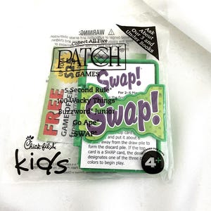 May include: A sealed package of children's card games, including "Swap!" and "5 Second Rule." The games are in a clear plastic bag with the Chick-fil-A Kids logo. The "Swap!" game has green and purple accents.