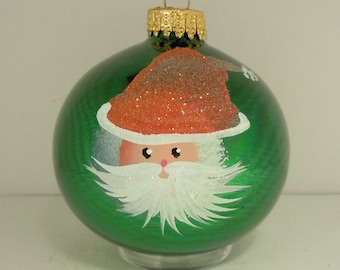 Hand painted santa on green glass christmas ornament